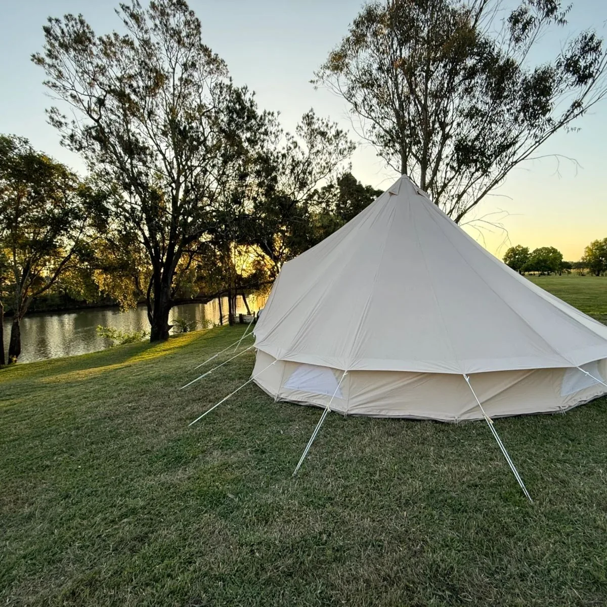 Bell tent pitched beside the river at sunset, East Coraki