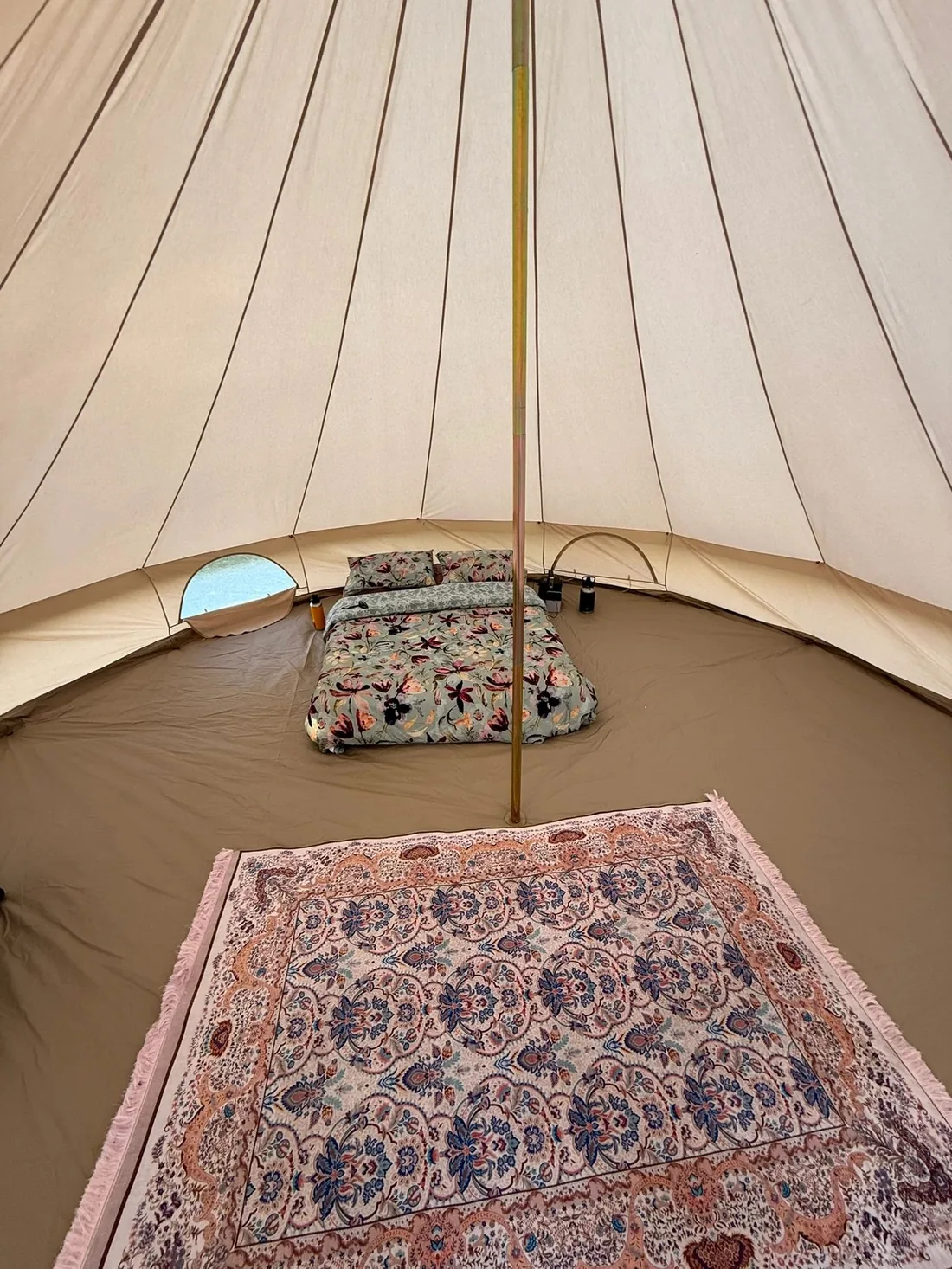 Inside a bell tent with rug and floor mats laid out